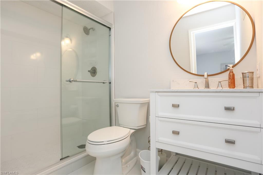 2214 Arbour Walk Circle, Unit 2012 Naples, FL 34109 - Photo 23 of 29 a bathroom with a sink a toilet and a mirror