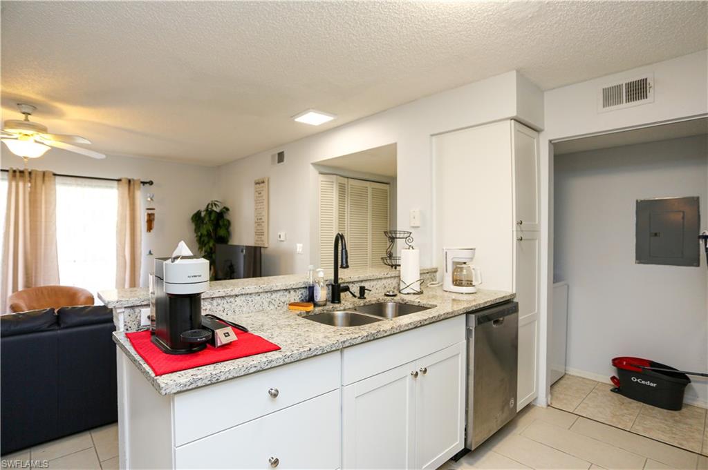 2214 Arbour Walk Circle, Unit 2012 Naples, FL 34109 - Photo 8 of 29 a kitchen with a sink and cabinets