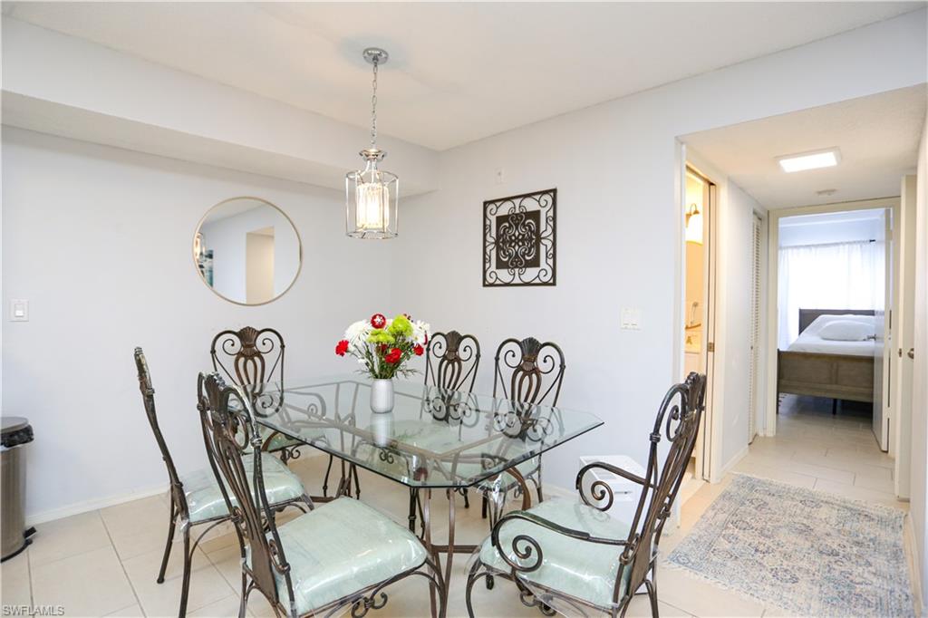 2214 Arbour Walk Circle, Unit 2012 Naples, FL 34109 - Photo 10 of 29 a view of a dining room with furniture and a chandelier