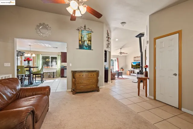 a kitchen with stainless steel appliances granite countertop a stove a sink dishwasher a dining table and chairs with wooden floor