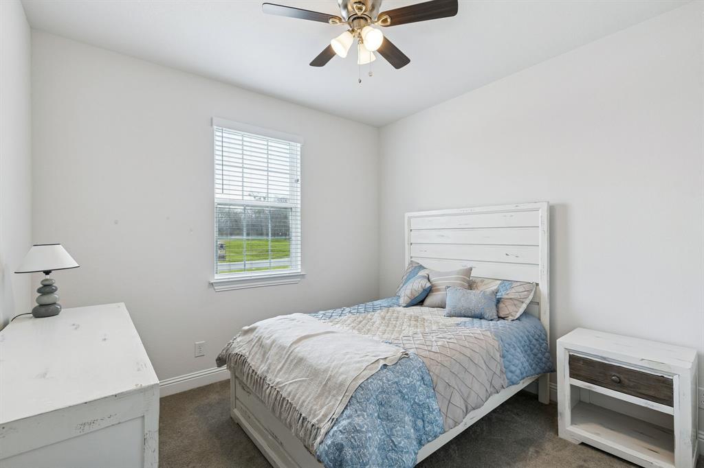 388 Montague Street Pilot Point, TX 76258 - Photo 21 of 28 a bedroom with a bed and a chandelier