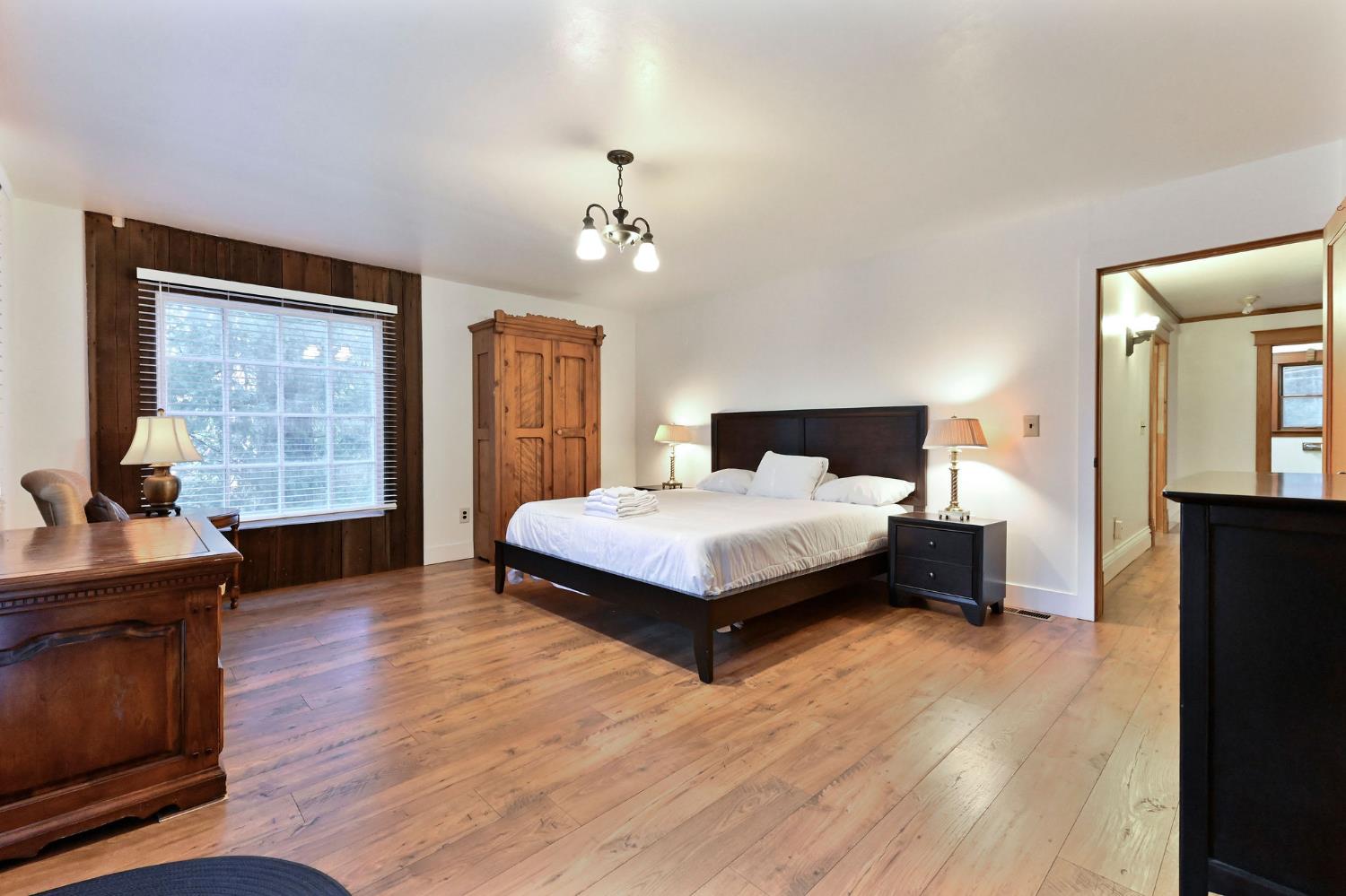 5276 Highway 4 Murphys, CA 95247 - Photo 21 of 69 a bedroom with a large bed a chandelier and dresser