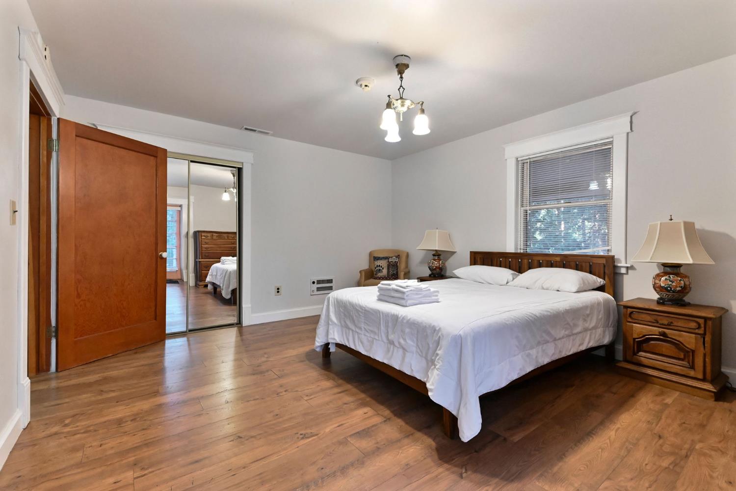 5276 Highway 4 Murphys, CA 95247 - Photo 48 of 69 a bedroom with a large bed chandelier and a window