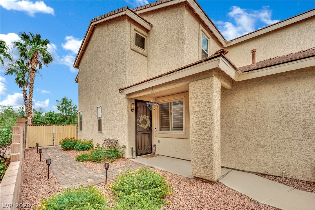 1724 Millstream Way Henderson, NV 89074 - Photo 6 of 60 A welcoming entry path leads to this desert oasis home with vibrant landscaping and robust stucco finish.