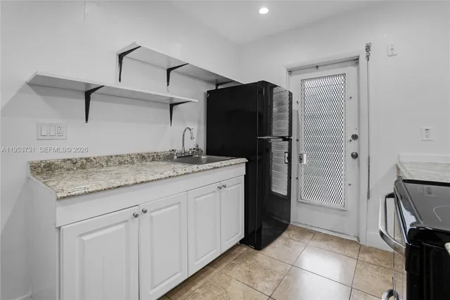 a kitchen with a refrigerator and a sink