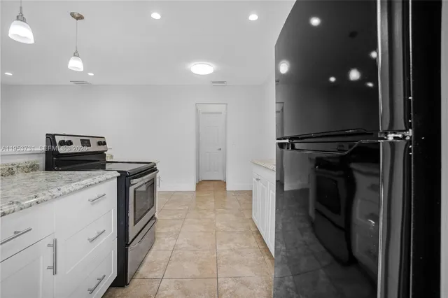 a kitchen with stainless steel appliances granite countertop a refrigerator and a sink