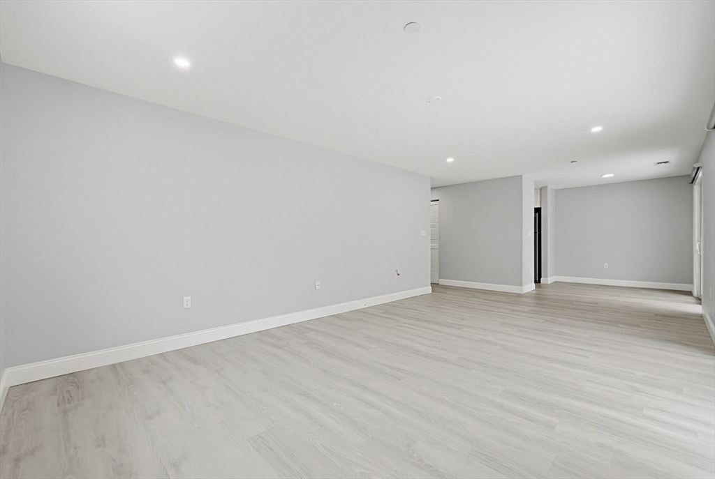 212 Franklin Crossing Road, Unit 12 Franklin, MA 02038 - Photo 8 of 11 an empty room with wooden floor and windows