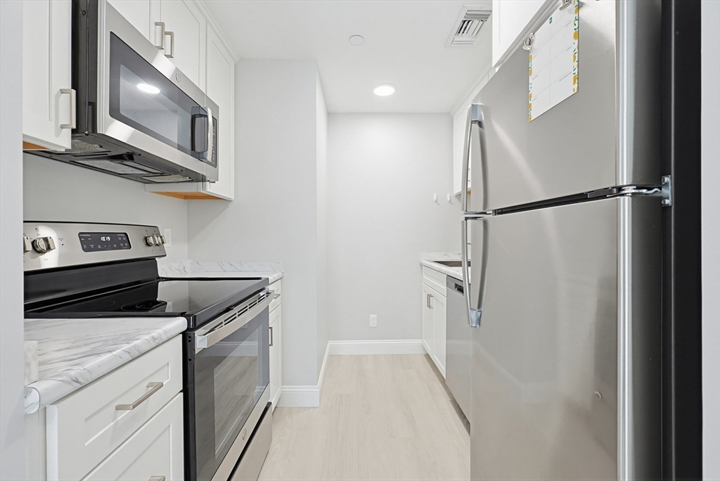 212 Franklin Crossing Road, Unit 12 Franklin, MA 02038 - Photo 9 of 11 a kitchen with stainless steel appliances a refrigerator and a stove