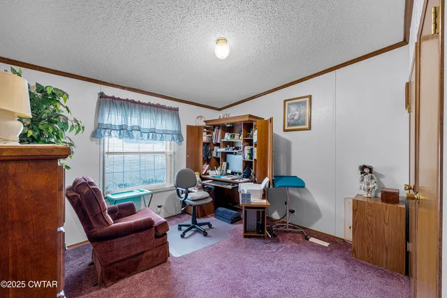 a view of a workspace with furniture and a window