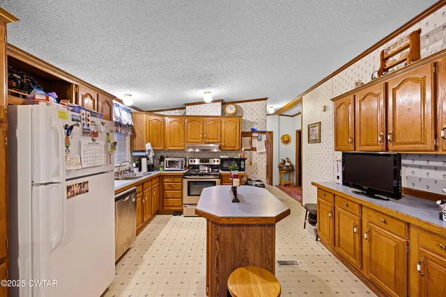 a kitchen with stainless steel appliances granite countertop a sink refrigerator and microwave