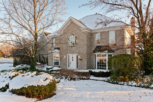 a front view of a house with a yard covered in snow
