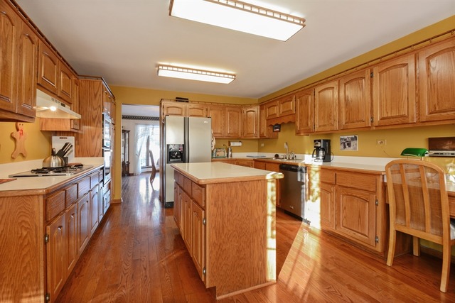 11445 Hummingbird Lane Mokena, IL 60448 - Photo 5 of 10 a kitchen with stainless steel appliances sink stove refrigerator and wooden cabinets