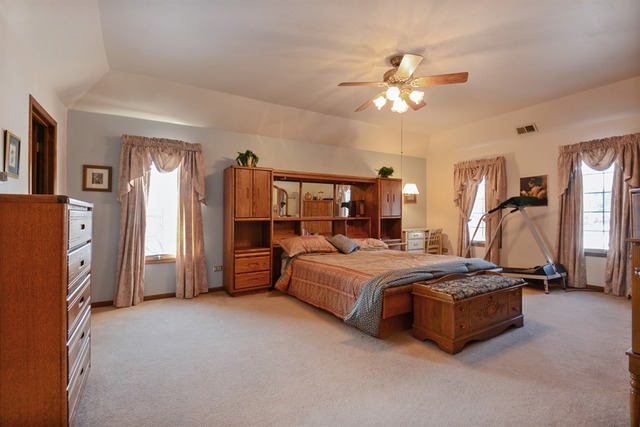 11445 Hummingbird Lane Mokena, IL 60448 - Photo 8 of 10 a spacious bedroom with a bed and a chandelier