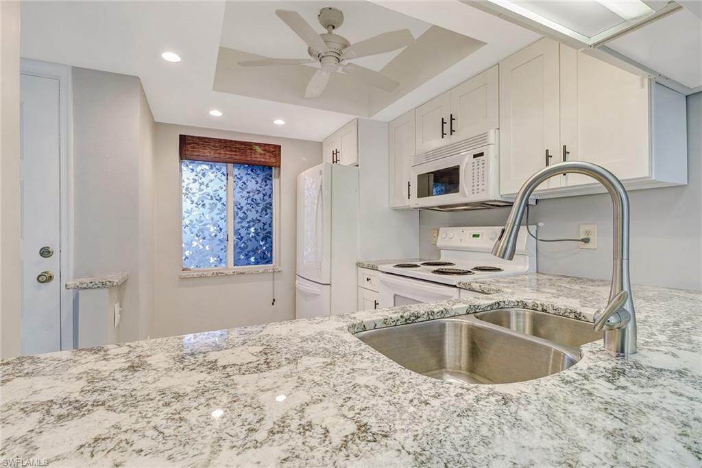 5809 Rattlesnake Hammock Road, Unit 102 Naples, FL 34113 - Photo 1 of 23 a kitchen with a stove a sink and a refrigerator