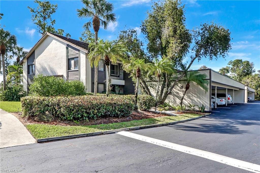 5809 Rattlesnake Hammock Road, Unit 102 Naples, FL 34113 - Photo 22 of 23 a front view of a house with garden