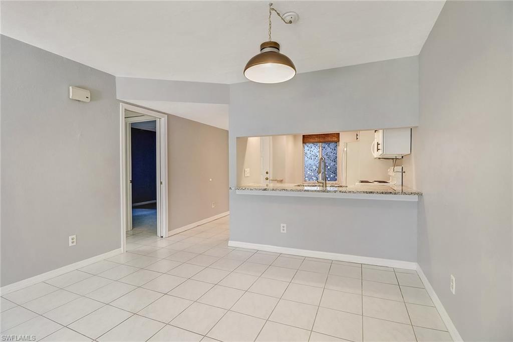 5809 Rattlesnake Hammock Road, Unit 102 Naples, FL 34113 - Photo 5 of 23 an empty room with a window and chandelier fan