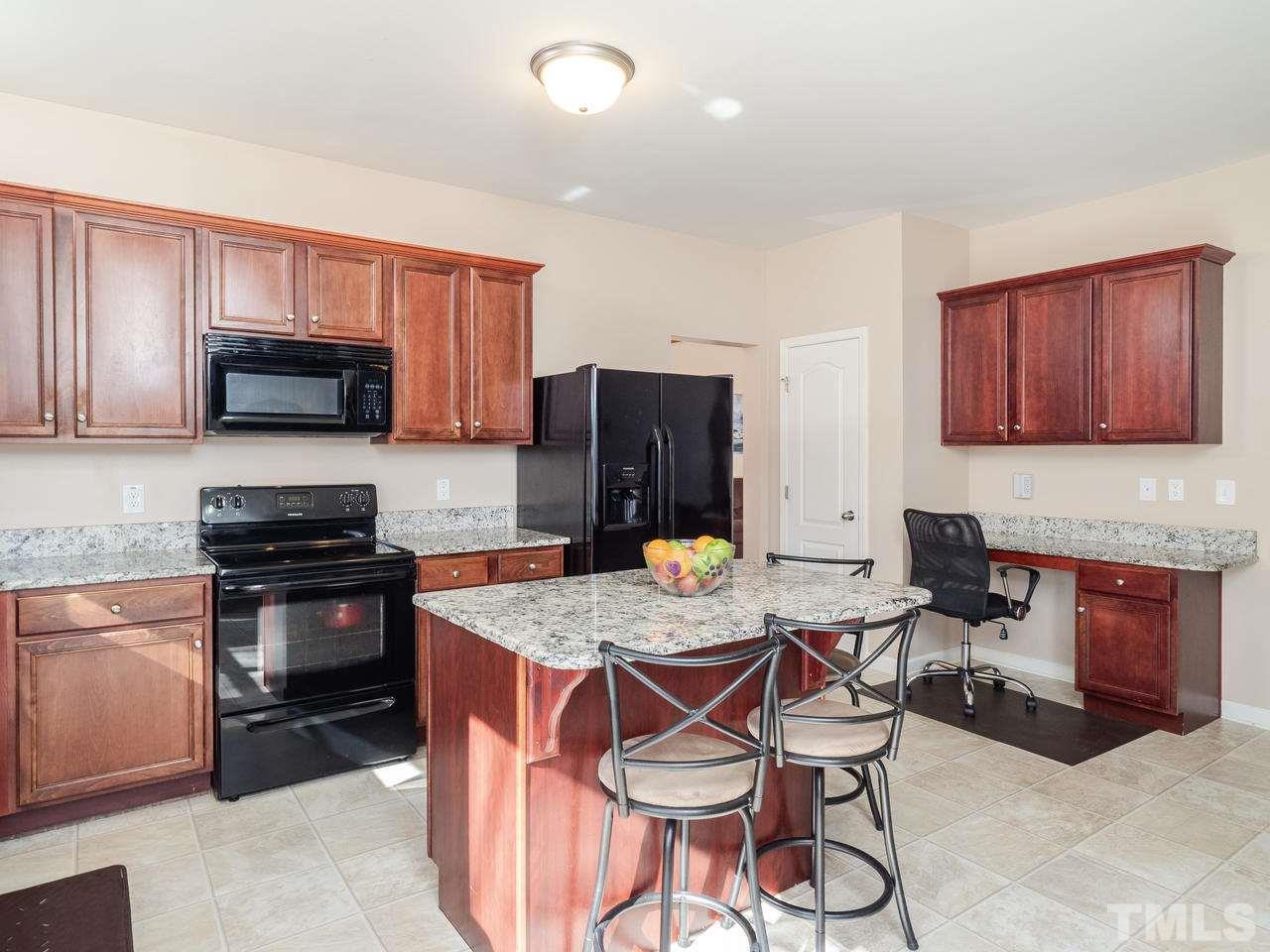 5624 Quitman Trail Raleigh, NC 27610 - Photo 12 of 25 a kitchen with a stove top oven a sink dishwasher and wooden cabinets with wooden floor