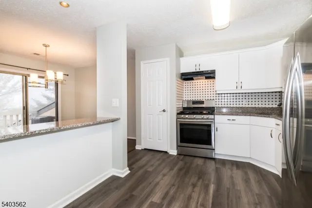 a kitchen with granite countertop a stove and a refrigerator