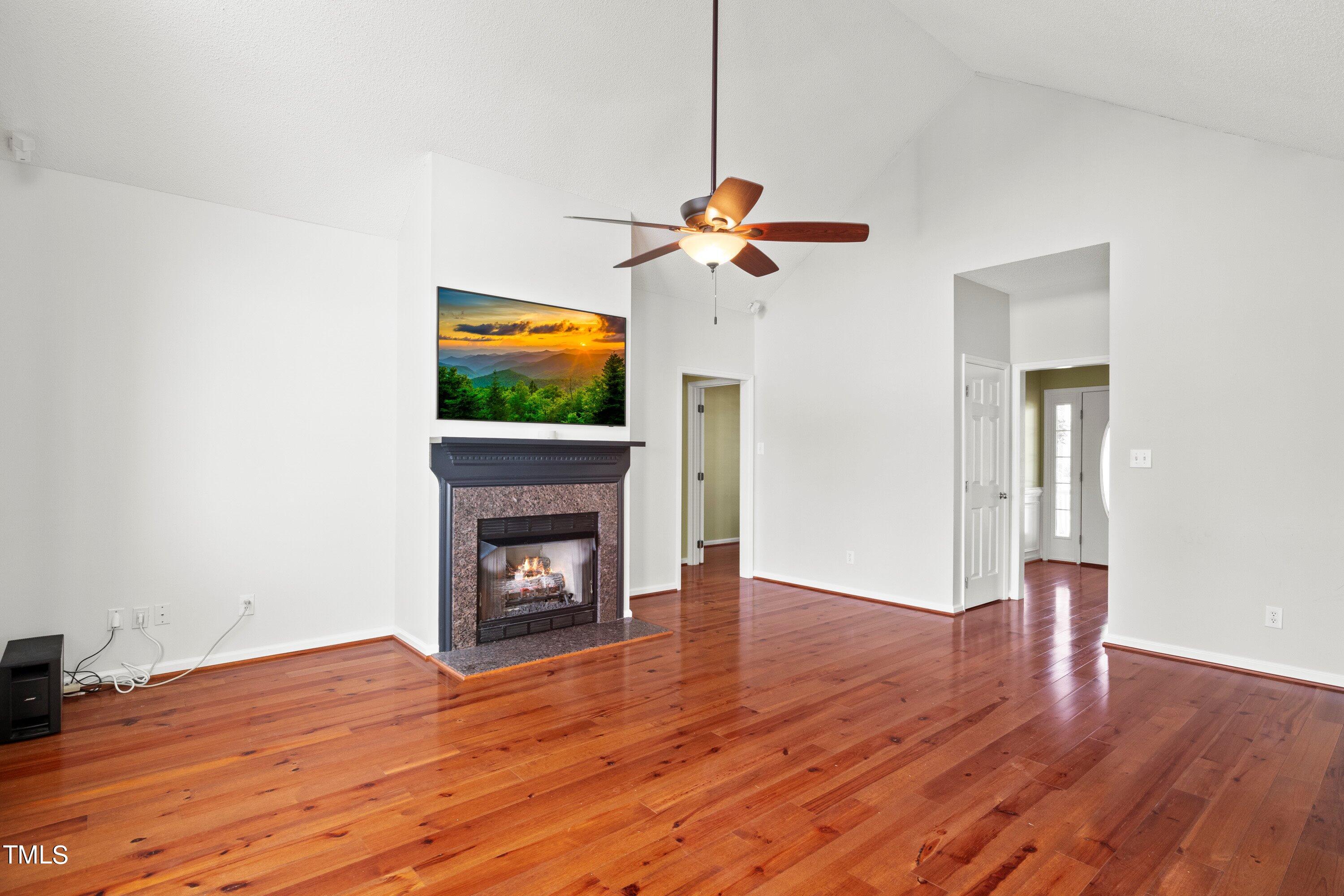 671 Old Evans Road Garner, NC 27529 - Photo 12 of 44 a view of an empty room with wooden floor and a fireplace