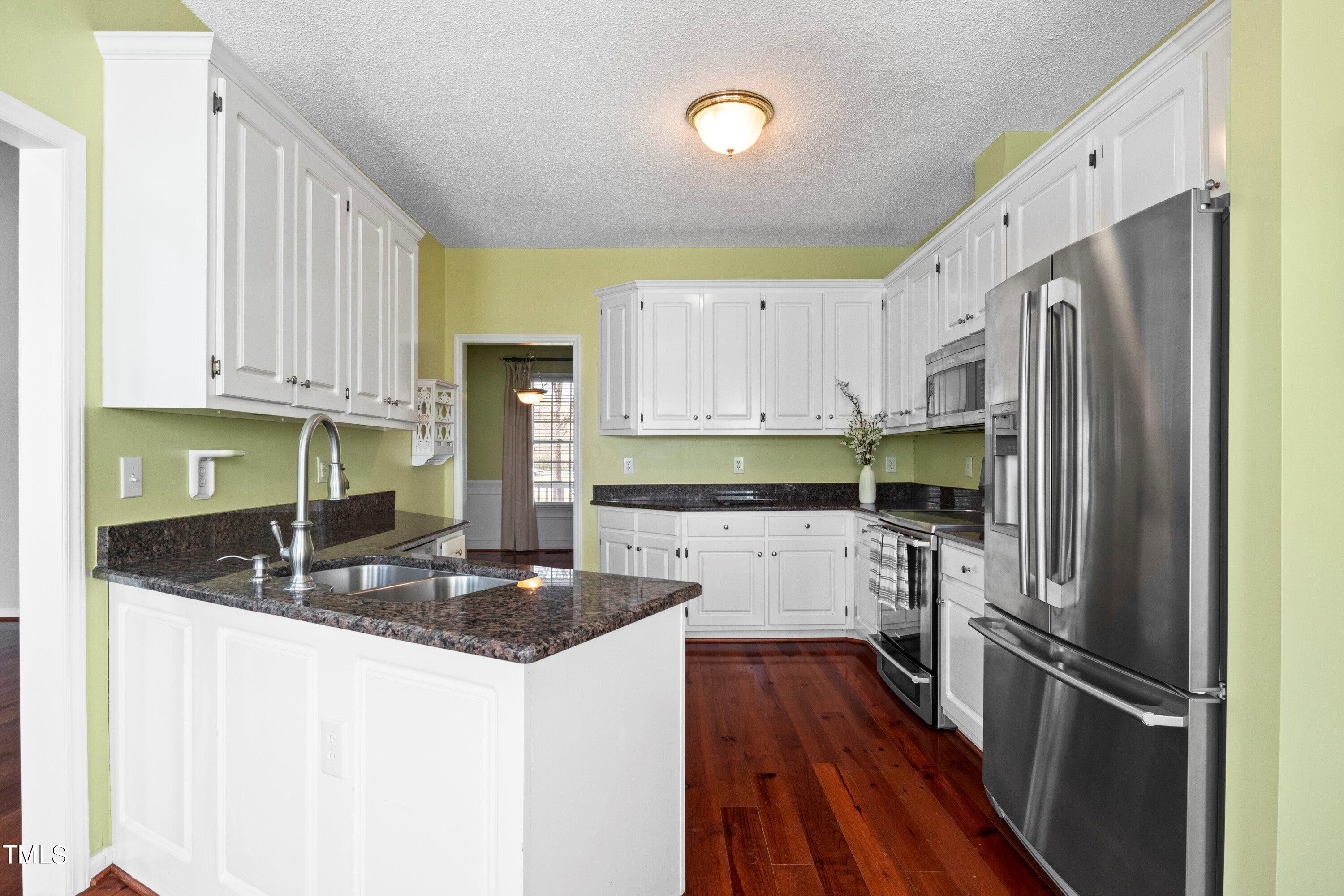 671 Old Evans Road Garner, NC 27529 - Photo 14 of 44 a kitchen with stainless steel appliances granite countertop a refrigerator sink and cabinets