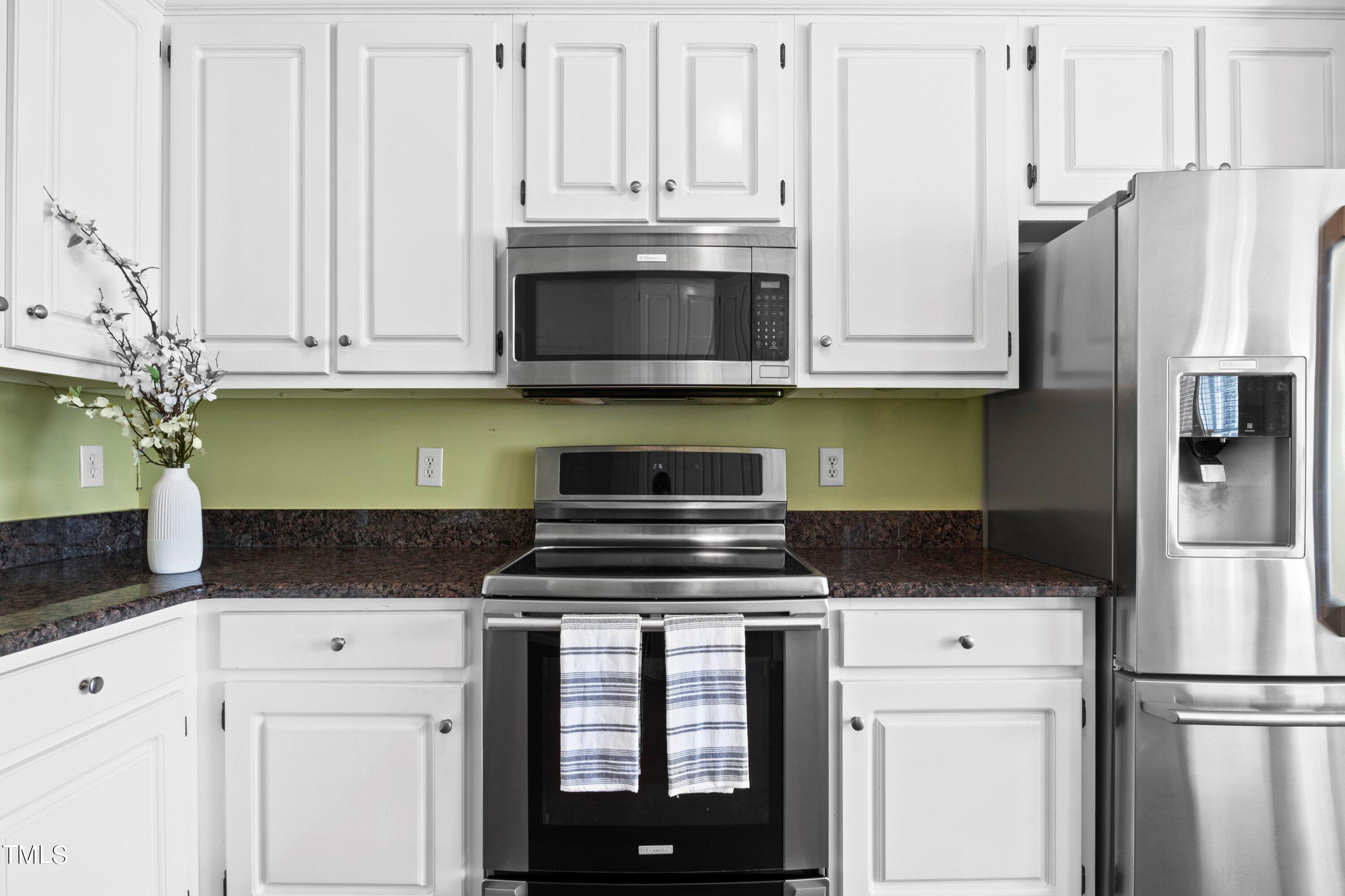 671 Old Evans Road Garner, NC 27529 - Photo 15 of 44 a kitchen with granite countertop a stove and white cabinets