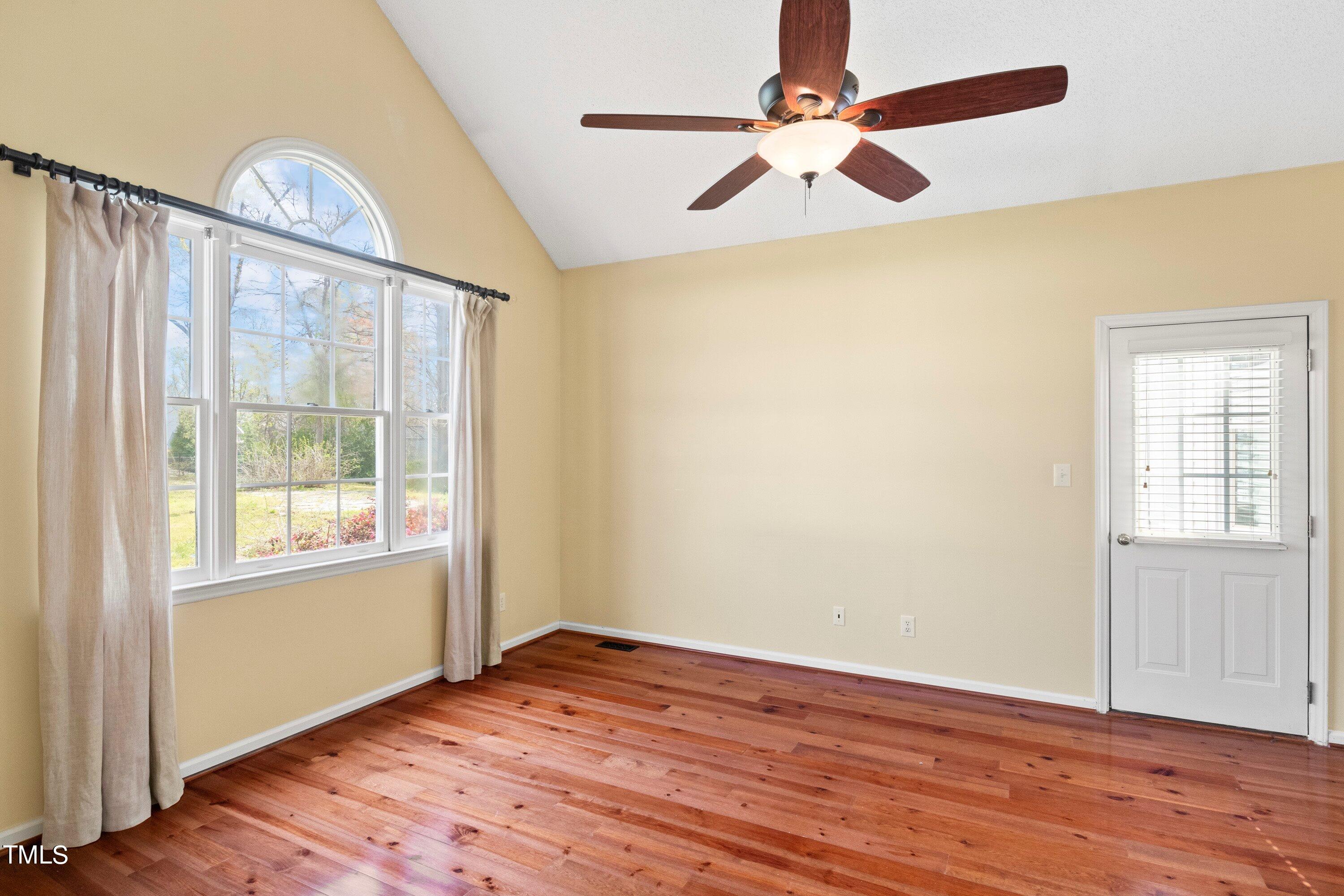 671 Old Evans Road Garner, NC 27529 - Photo 22 of 44 an empty room with wooden floor fan and windows