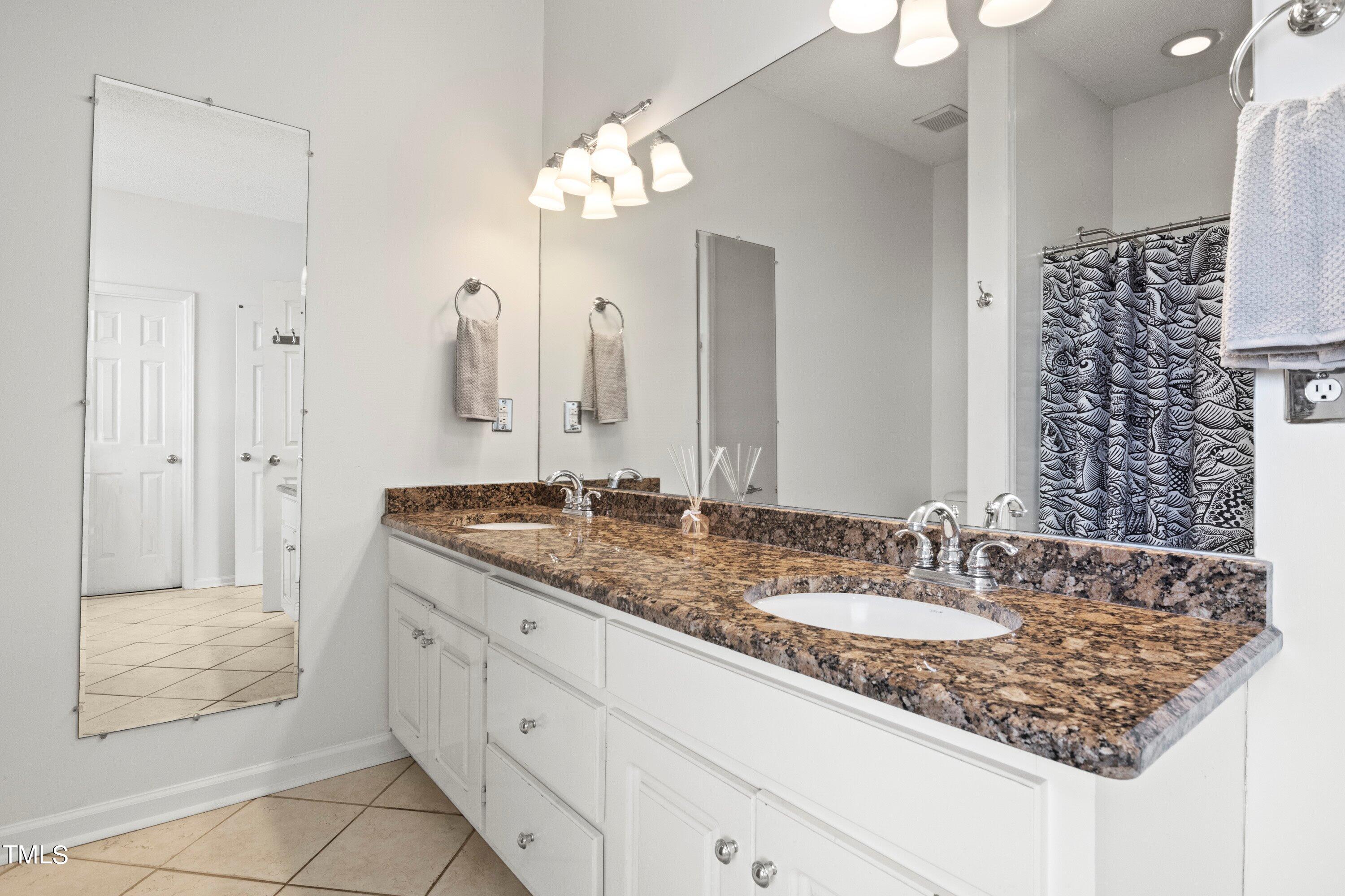 671 Old Evans Road Garner, NC 27529 - Photo 24 of 44 a bathroom with a granite countertop sink and a mirror
