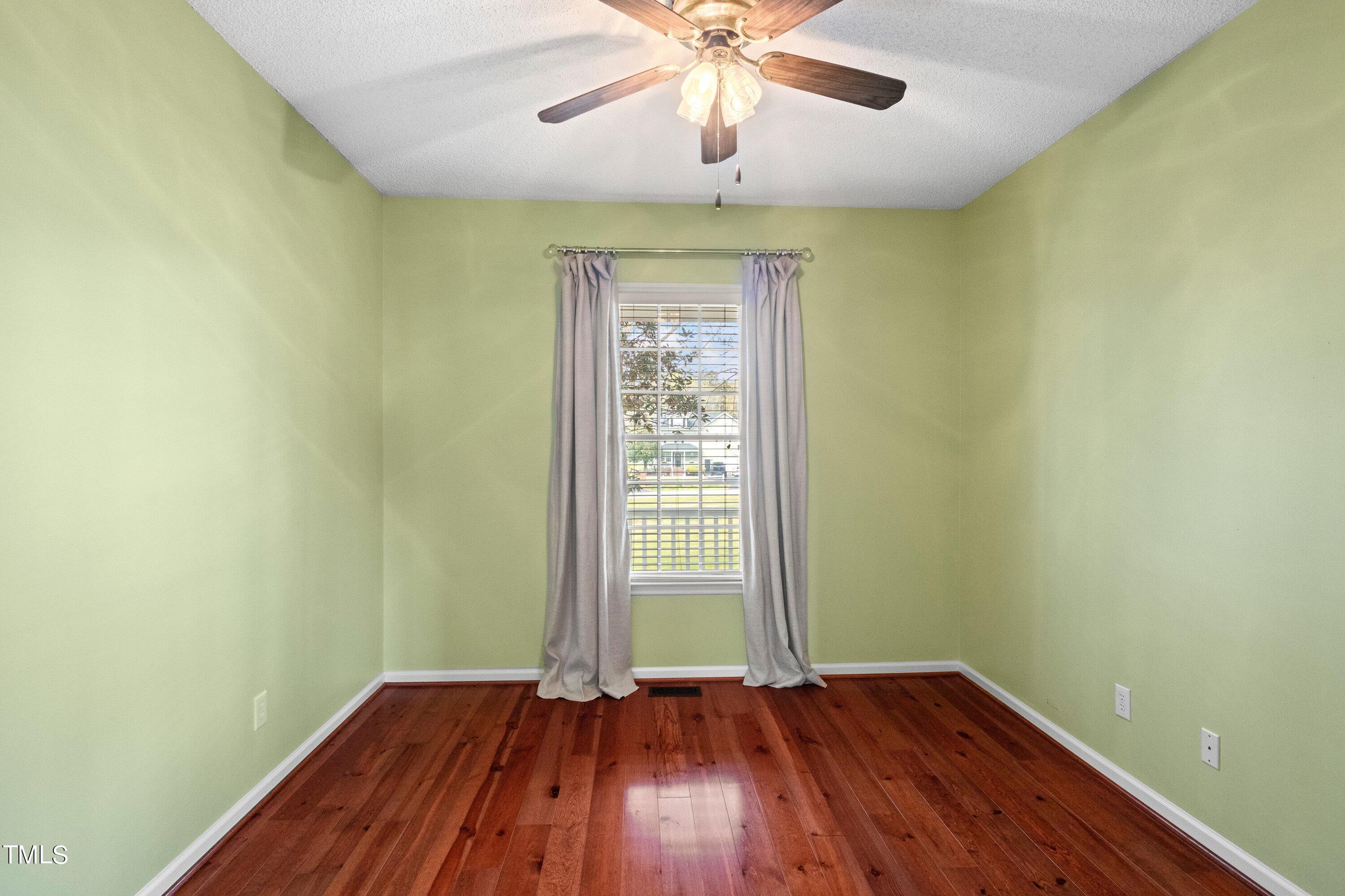 671 Old Evans Road Garner, NC 27529 - Photo 27 of 44 an empty room with wooden floor and windows