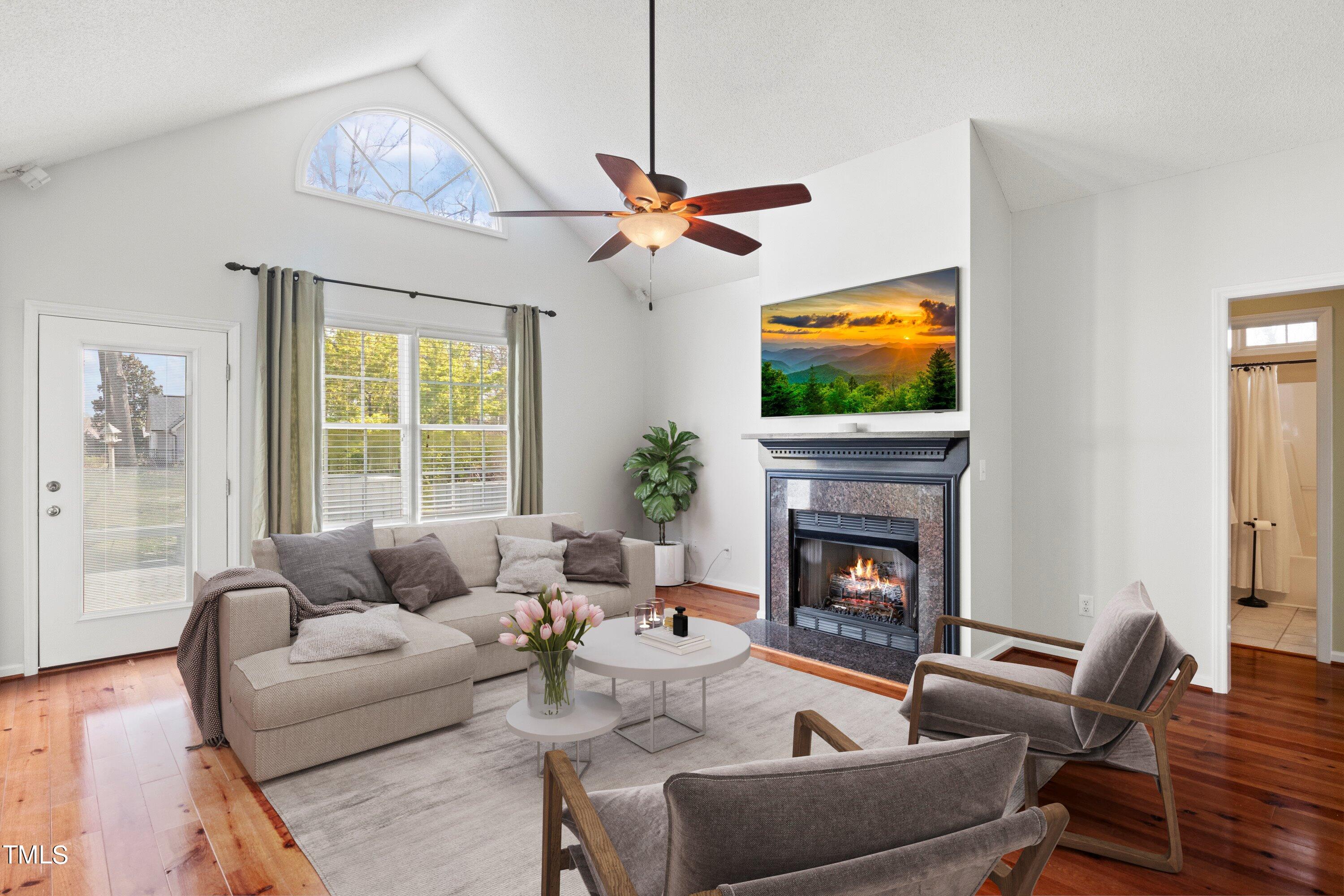 671 Old Evans Road Garner, NC 27529 - Photo 9 of 44 a living room with furniture a fireplace and a flat screen tv