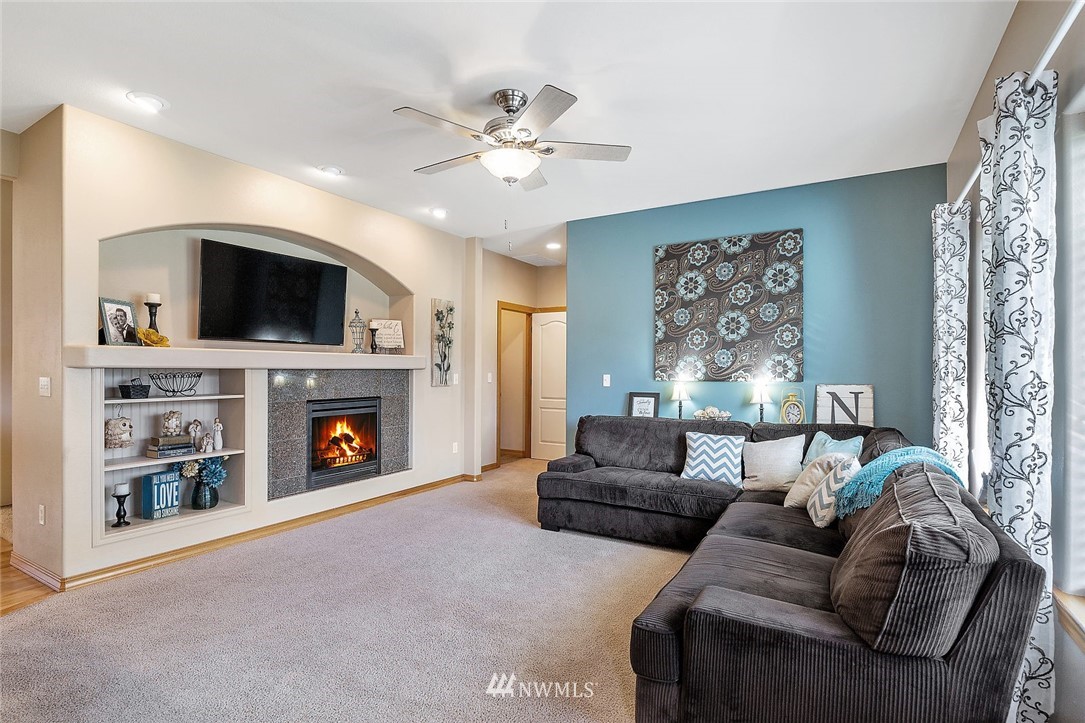 3124 172 Street Southeast Bothell, WA 98012 - Photo 12 of 25 a living room with furniture a fireplace and a flat screen tv