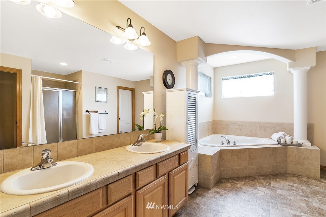 3124 172 Street Southeast Bothell, WA 98012 - Photo 17 of 25 a bathroom with a tub a double vanity sink and mirror