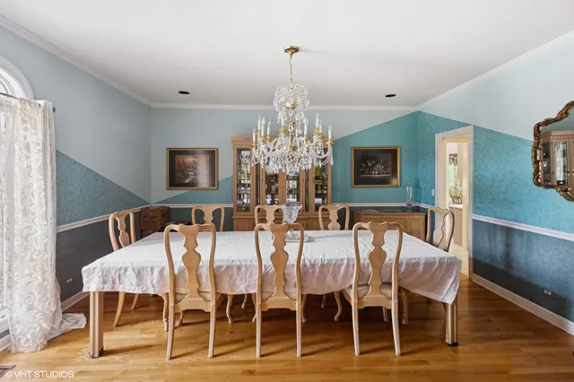 a view of a dining room with furniture a chandelier and wooden floor