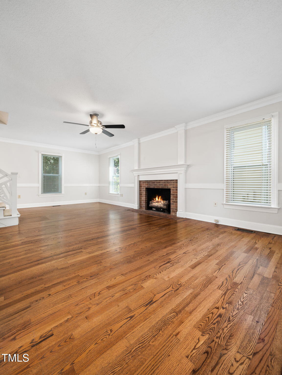 3909 Iron Horse Road Raleigh, NC 27616 - Photo 8 of 47 an empty room with wooden floor fire place and windows