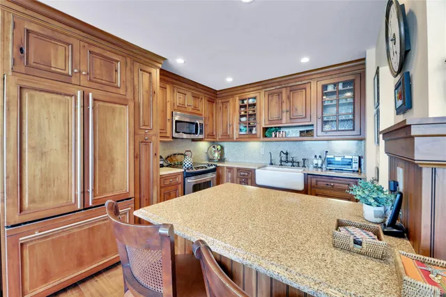 a kitchen with stainless steel appliances granite countertop a refrigerator and a stove top oven