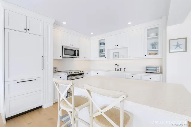 a kitchen with stainless steel appliances white cabinets and a refrigerator