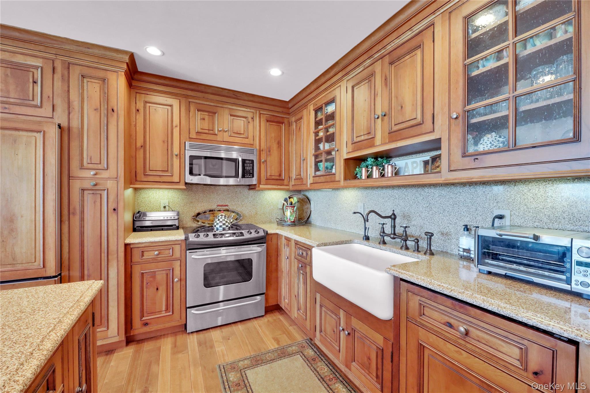 279 Dune Road, Unit 2 Westhampton Beach, NY 11978 - Photo 15 of 45 a kitchen with stainless steel appliances granite countertop a stove and a sink