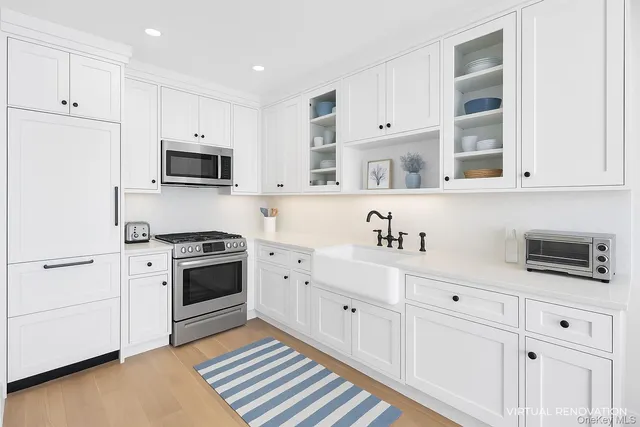 a kitchen with granite countertop white cabinets and stainless steel appliances