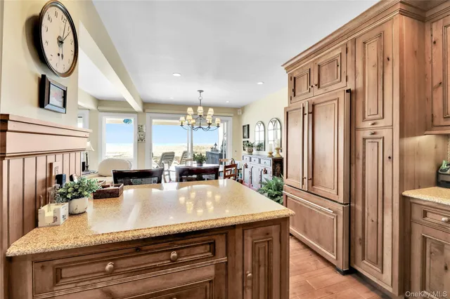 a kitchen with stainless steel appliances granite countertop a refrigerator a stove and a sink with wooden floor