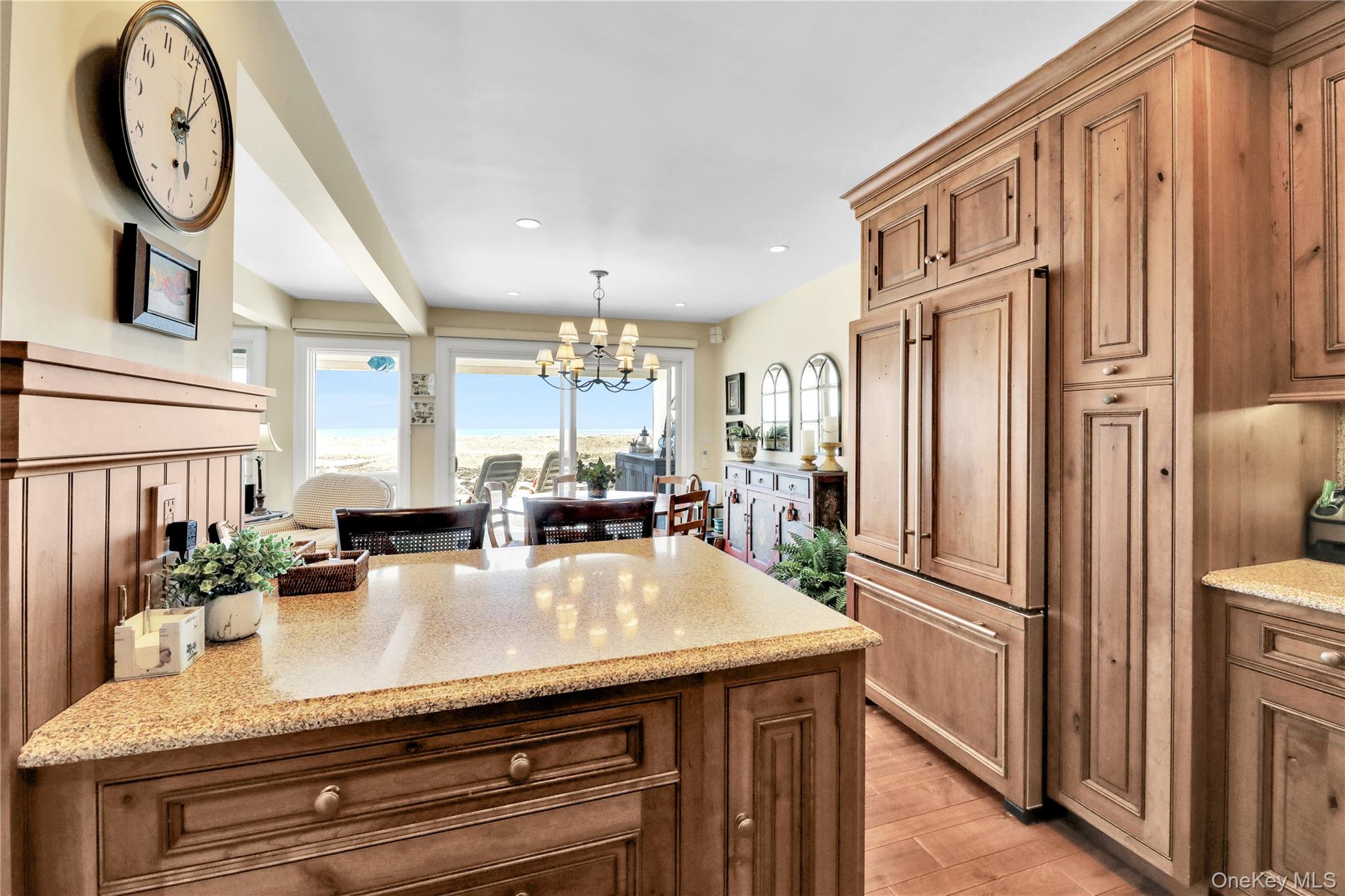 279 Dune Road, Unit 2 Westhampton Beach, NY 11978 - Photo 17 of 45 a kitchen with stainless steel appliances granite countertop a refrigerator a stove and a sink with wooden floor