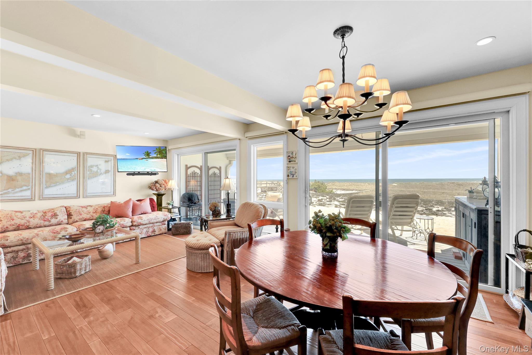 279 Dune Road, Unit 2 Westhampton Beach, NY 11978 - Photo 18 of 45 a view of a dining room with furniture a chandelier and large windows