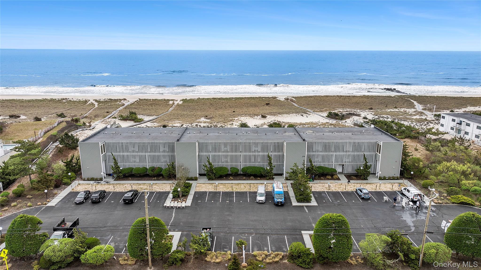 279 Dune Road, Unit 2 Westhampton Beach, NY 11978 - Photo 3 of 45 a view of swimming pool with outdoor seating and ocean view