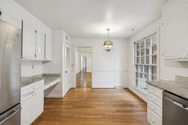 a view of a kitchen with wooden floor and electronic appliances