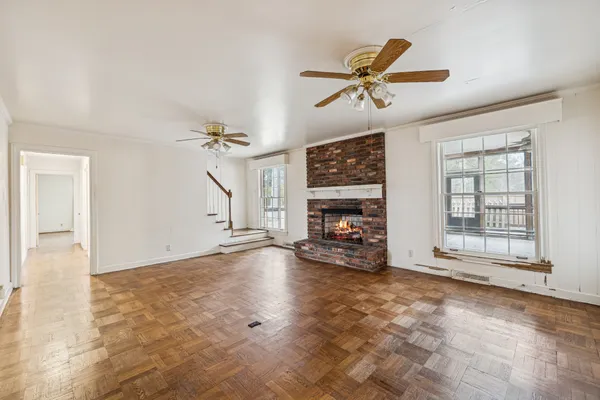 an empty room with windows and ceiling fan