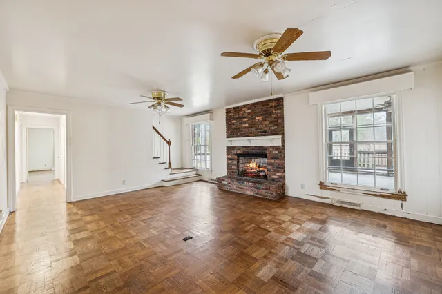 an empty room with windows and ceiling fan