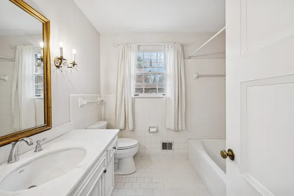 a bathroom with a granite countertop sink a toilet and shower