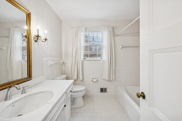 a bathroom with a granite countertop sink a toilet and shower