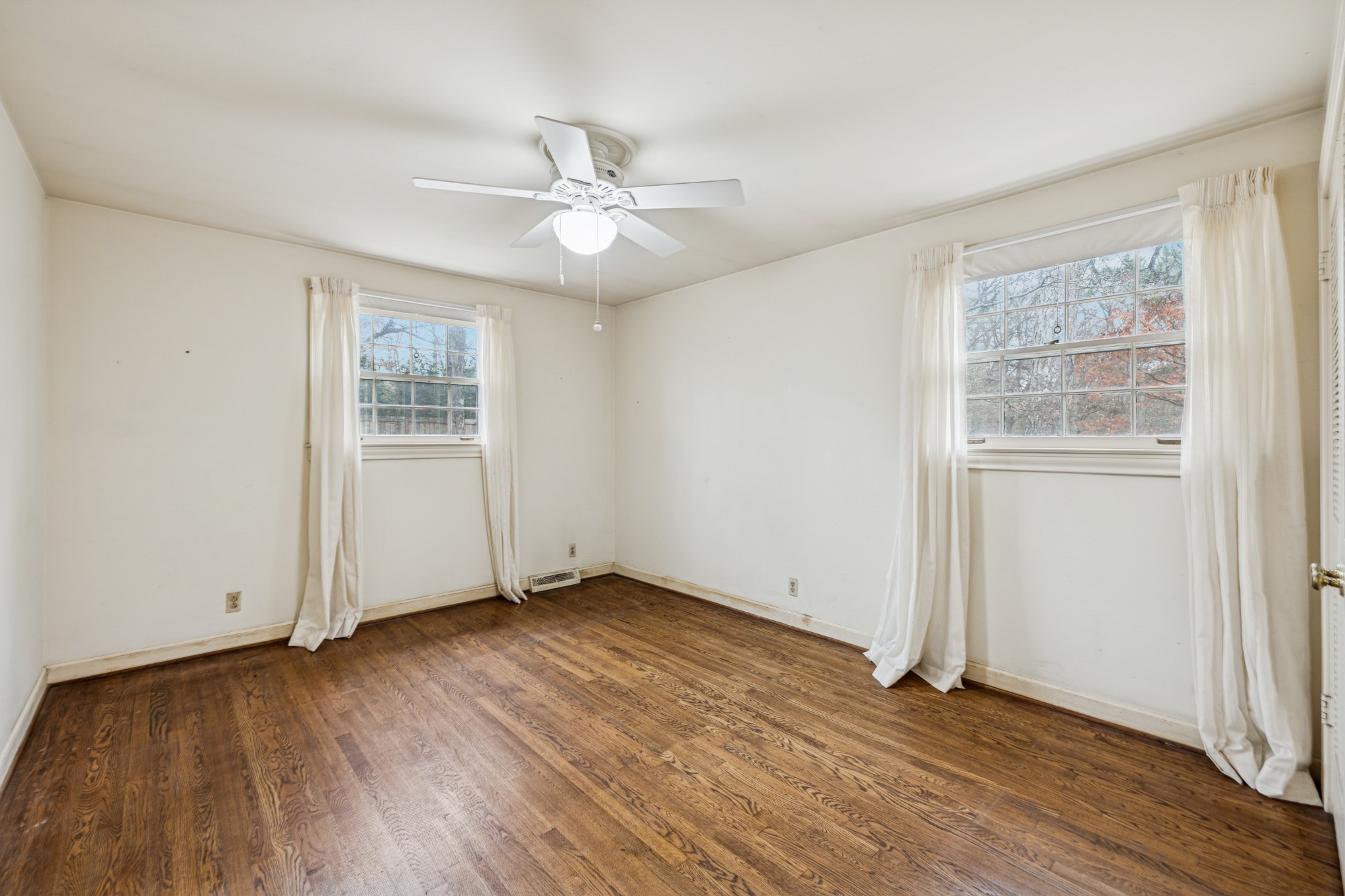 718 Murfreesboro Road Franklin, TN 37064 - Photo 20 of 35 an empty room with wooden floor chandelier fan and windows