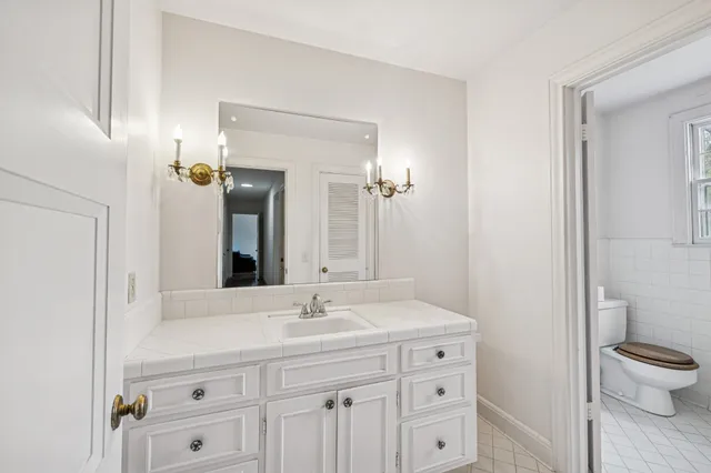 a bathroom with a sink a toilet and a mirror