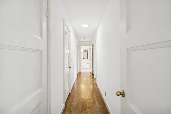 a view of a hallway with wooden floor