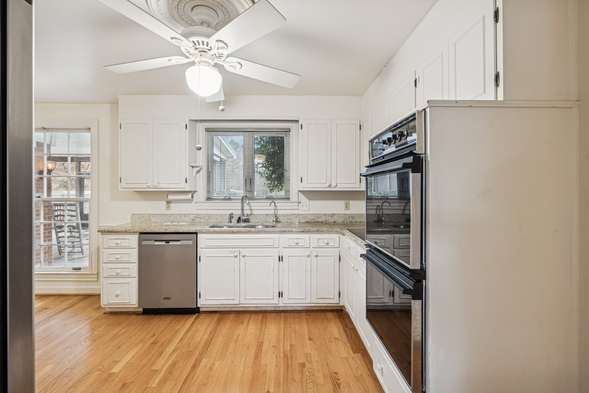 718 Murfreesboro Road Franklin, TN 37064 - Photo 8 of 35 a kitchen with a sink dishwasher a stove and white cabinets with wooden floor